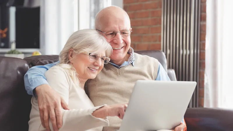 Casal de aposentados consultando informações em um notebook